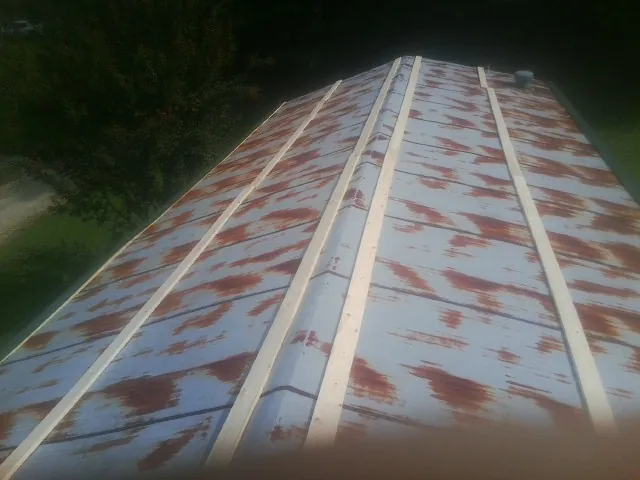 Rusted metal roof panels with new wood purlins before replacement — Storm Damage Roof Repair in Wells by Roofing Brothers